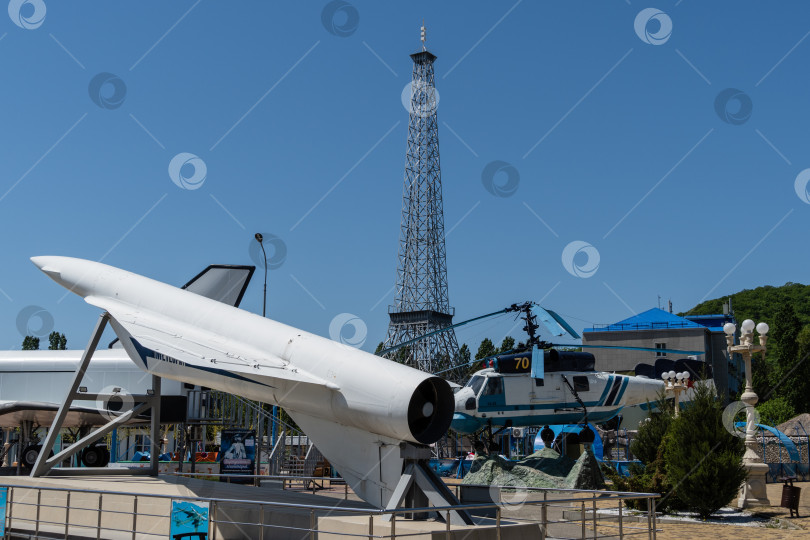 Скачать Вертолет Ка-25 и советская крылатая ракета на фоне макета Эйфелевой башни в Архипо-Осиповке. Макет Эйфелевой башни на фоне голубого неба. фотосток Ozero