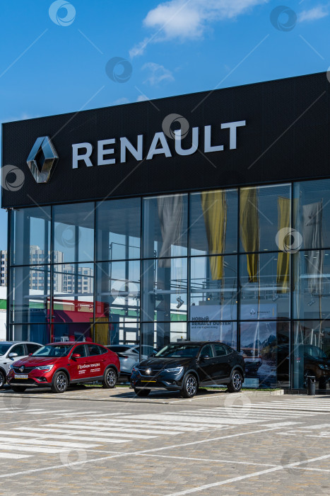 Скачать Новые автомобили Renault различных цветов припаркованы возле дилерского центра Renault. На фасаде здания есть надпись Renault с логотипом. Дилерский центр. Мега Адыгея. фотосток Ozero