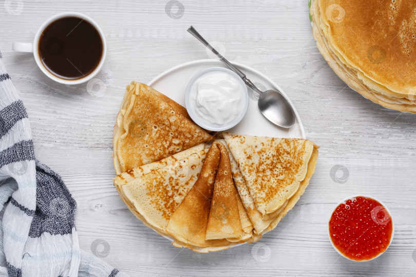 Скачать Блинчики подаются со сметаной и красной икрой на деревянном столе в сопровождении кофе и полотенца в уютной обстановке фотосток Ozero