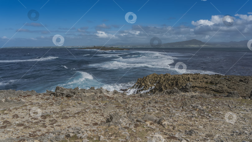 Скачать В проливе между островками бушуют волны. Белая пена на голубой воде. фотосток Ozero