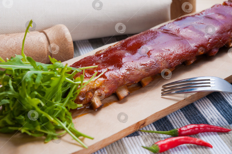 Скачать вкусные свиные ребрышки целиком с соусом барбекю фотосток Ozero