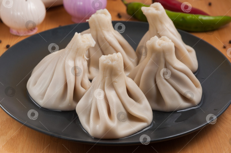 Скачать Грузинские хинкали с курицей на темной тарелке фотосток Ozero