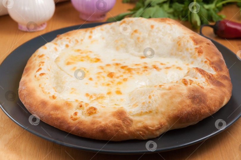 Скачать Хачапури по-мегрельски грузинской кухни на темной тарелке фотосток Ozero