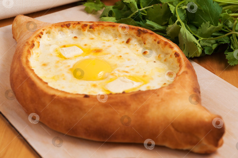 Скачать традиционная грузинская кухня. Хачапури по-аджарски на деревянной доске фотосток Ozero