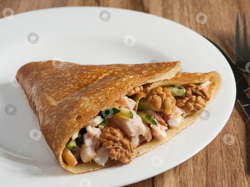 Скачать блинчик с копченой курицей и грецкими орехами на белой тарелке фотосток Ozero
