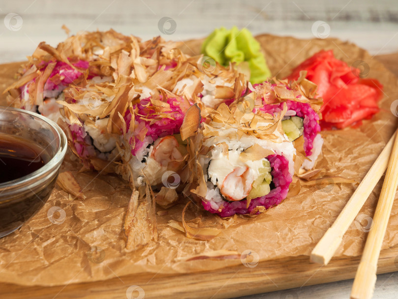 Скачать суши-ролл с креветками, сливочным сыром и стружкой из угря. Закрыть фотосток Ozero