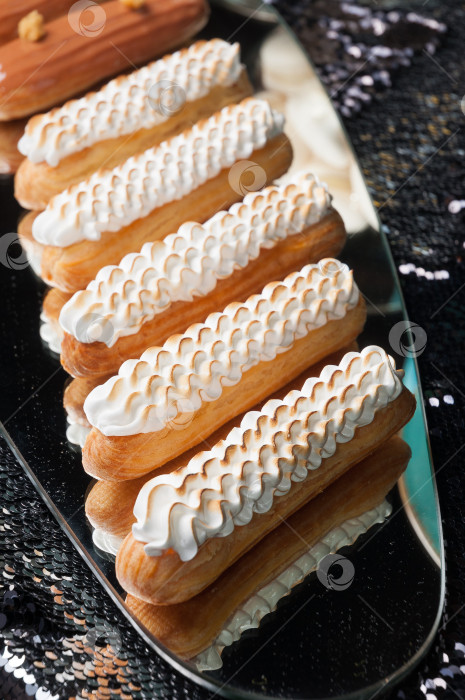 Скачать Эклер с подгоревшим белковым кремом на зеркальце фотосток Ozero