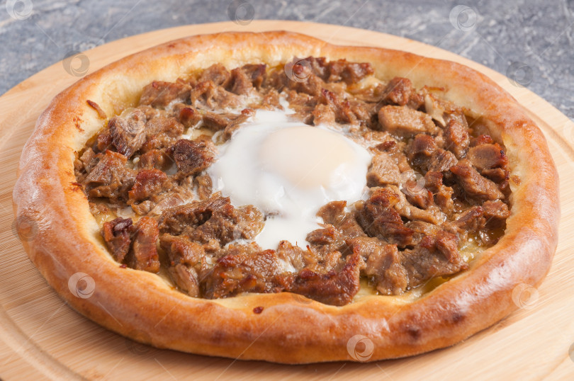 Скачать Традиционная турецкая кухня - это караденизская пита, Кавурмали Трабзон Пидеси, пика из тушеного мяса и яиц. фотосток Ozero