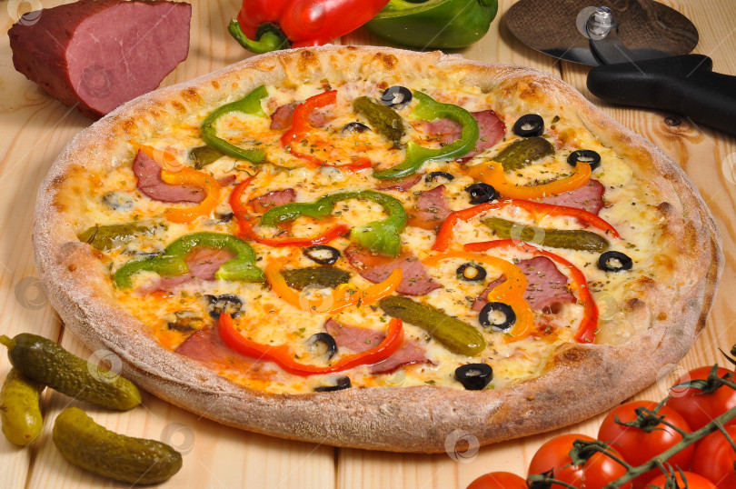 Скачать пицца с копченым мясом, болгарским перцем, маринованными огурцами и сыром моцарелла фотосток Ozero