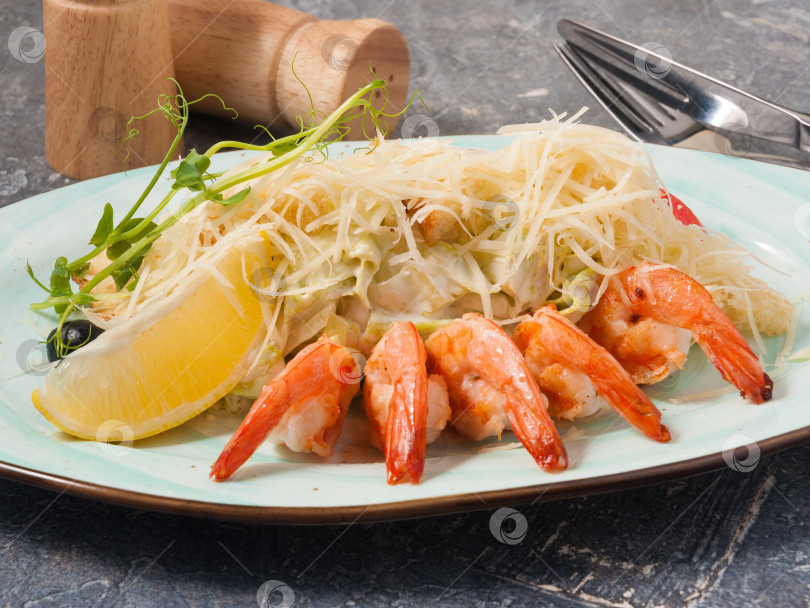 Скачать вкусный Цезарь с креветками в ресторане на сером фоне фотосток Ozero