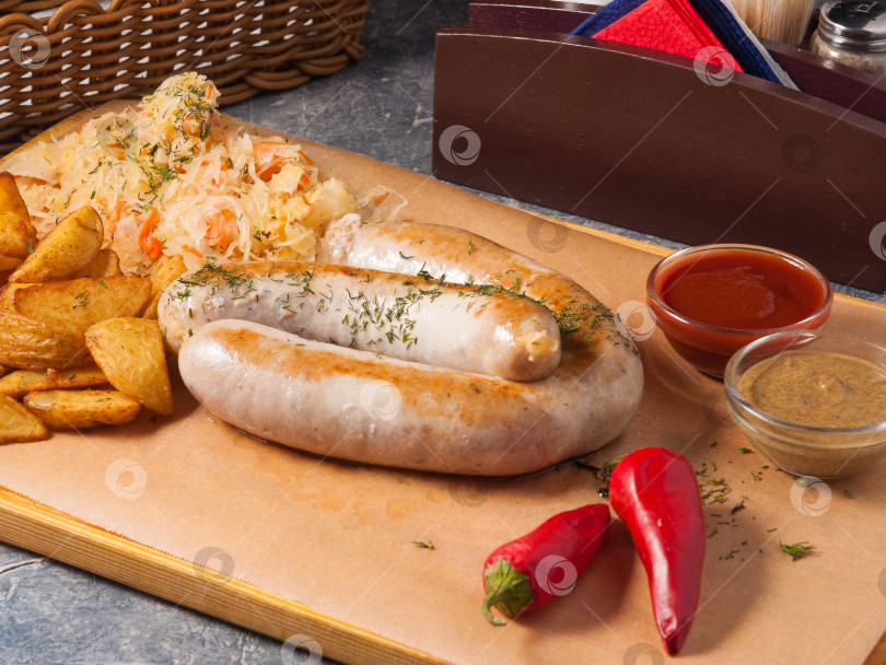 Скачать сосиски с грибами, ломтиками картофеля, капустой и соусами фотосток Ozero