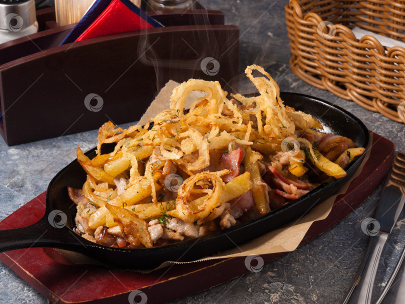 Скачать картофель с мясом, беконом и луком на сковороде фотосток Ozero