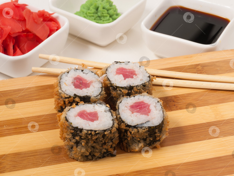 Скачать вкусные горячие суши-роллы с тунцом на деревянной доске фотосток Ozero