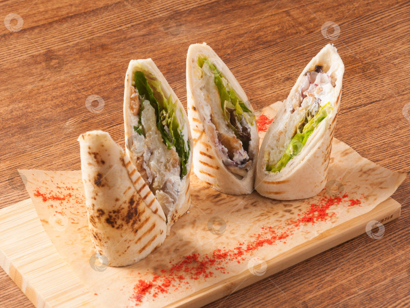 Скачать нарезанная ломтиками тортилья с курицей на деревянной доске фотосток Ozero