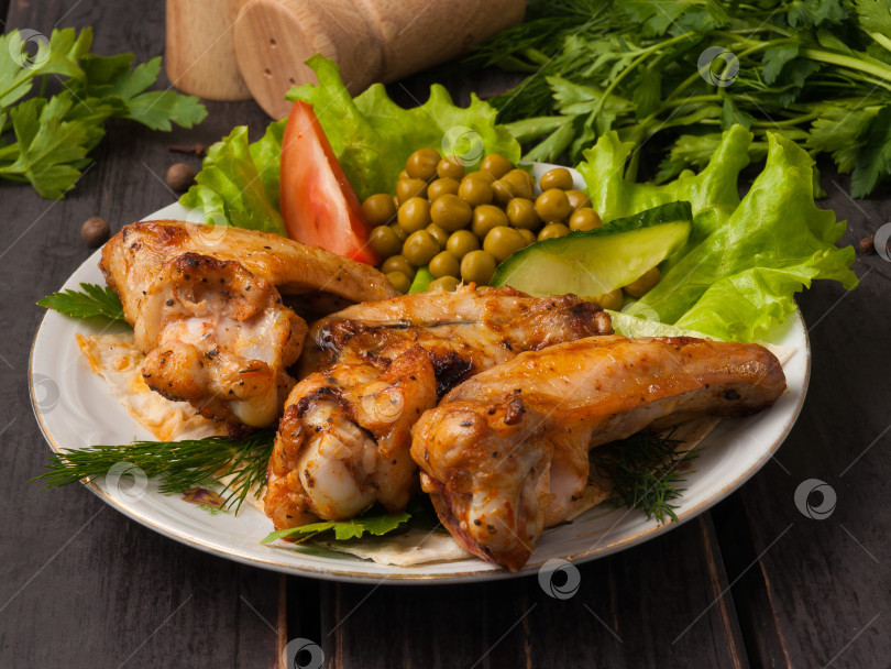 Скачать вкусные куриные крылышки-гриль, украшенные овощами фотосток Ozero