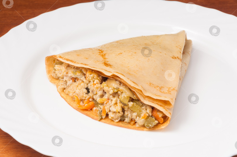 Скачать блинчики с мясным фаршем и овощами на белой тарелке фотосток Ozero