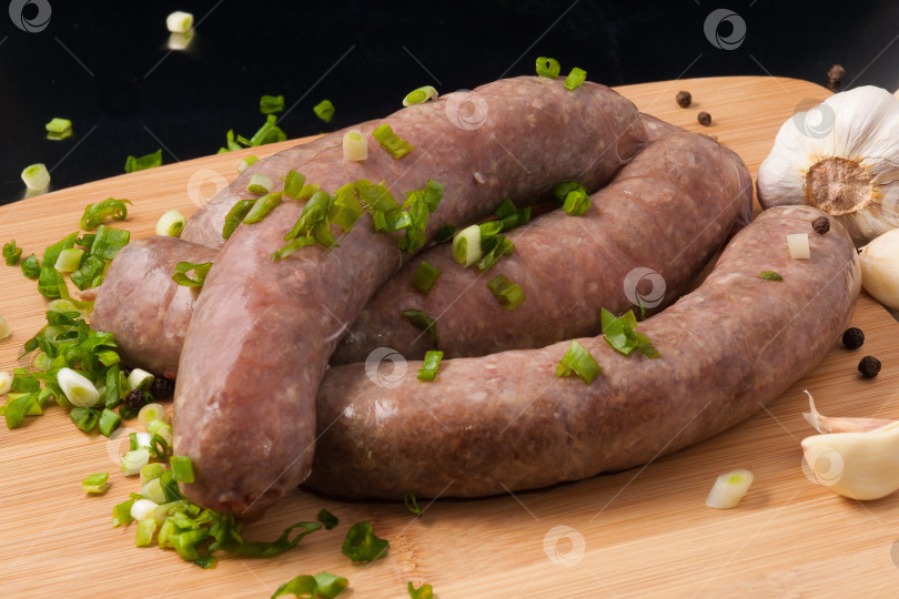 Скачать колбаски из сырого мяса для запекания на гриле с зеленым луком фотосток Ozero
