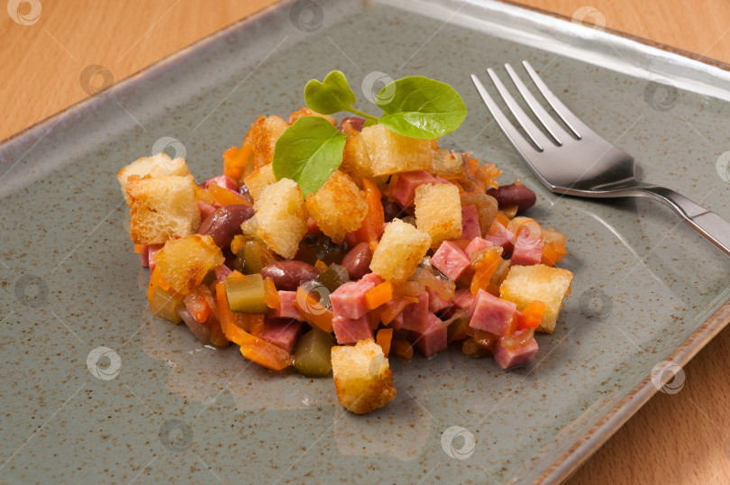 Скачать салат с копченой колбасой, овощами и гренками фотосток Ozero