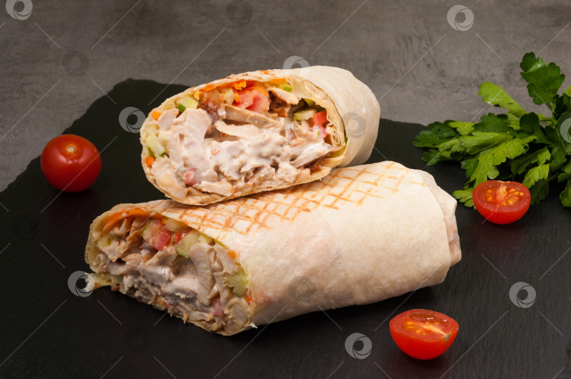 Скачать большая шаурма с овощами и курицей на темном фоне фотосток Ozero