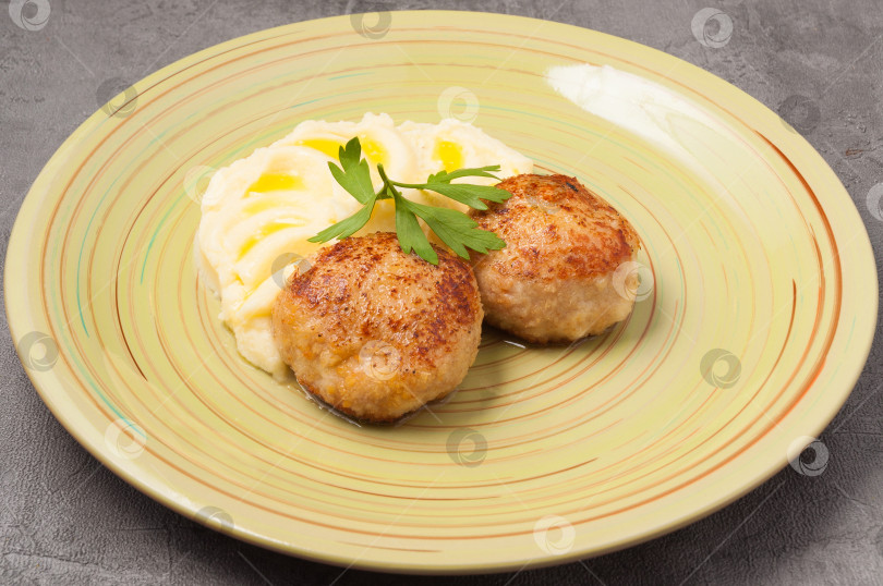 Скачать пюре со сливочным маслом и куриными котлетами, украшенными листиком петрушки фотосток Ozero