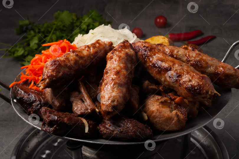Скачать Казан-кебаб - мясное ассорти, разогретое на огне. Традиционное азиатское блюдо фотосток Ozero