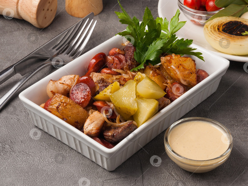 Скачать горячая закуска картофель сосиски курица и свинина с луком и соусом фотосток Ozero