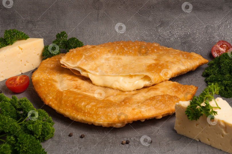 Скачать горячая закуска: чебурек с сыром на сером фоне фотосток Ozero