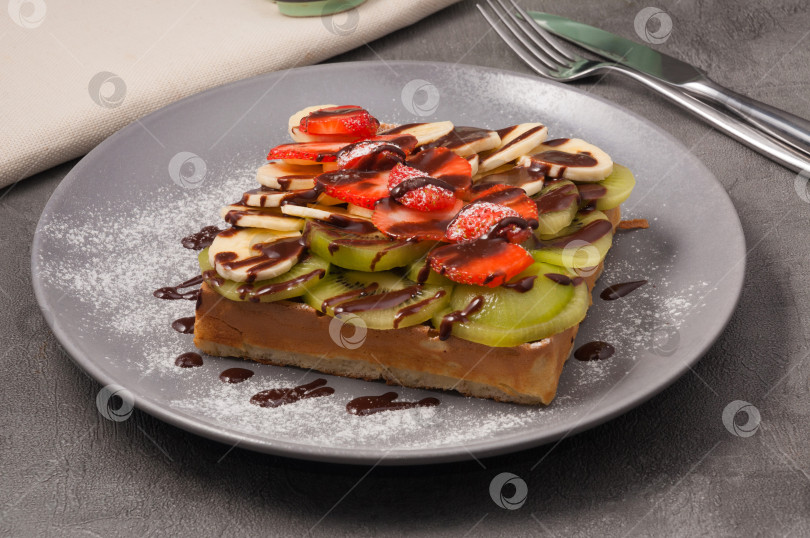 Скачать вафли с киви, бананом и клубникой, политые шоколадным сиропом фотосток Ozero