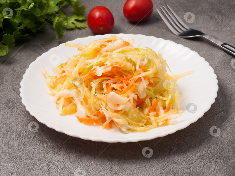 Скачать салат из капусты и моркови на белой тарелке. крупный план фотосток Ozero