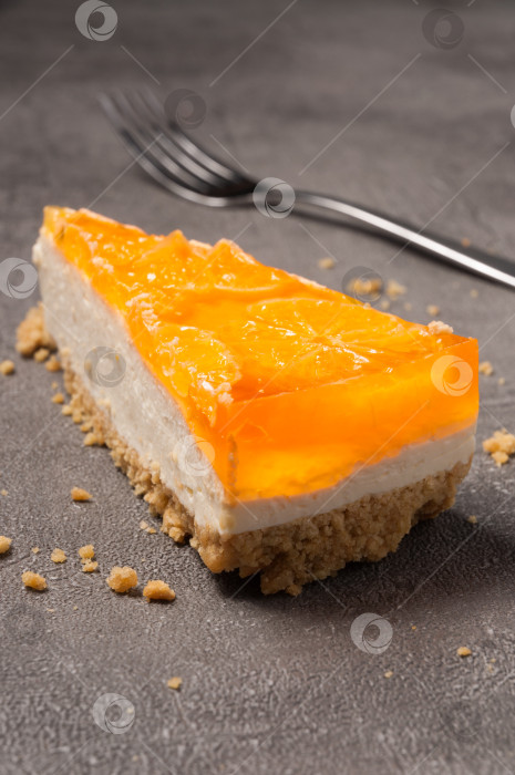 Скачать апельсиновый чизкейк на сером фоне. крупный план фотосток Ozero