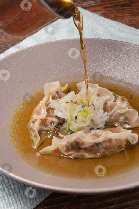 Скачать димсамы с овощами и лесными грибами поливают соусом фотосток Ozero