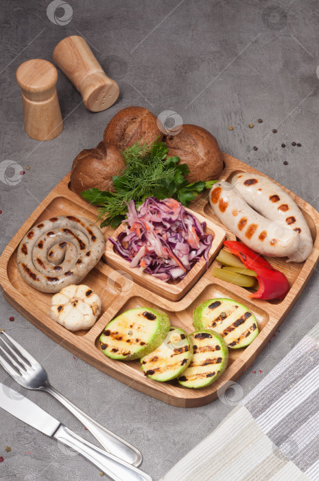Скачать тарелка с сосисками-гриль, цукини, красной капустой и булочками фотосток Ozero