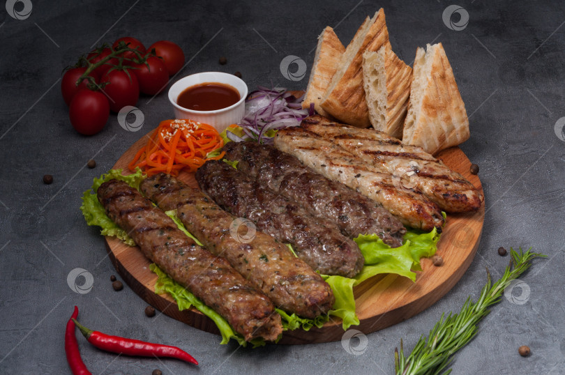 Скачать люля-кебаб ассорти из свинины, баранины, курицы на деревянной доске фотосток Ozero