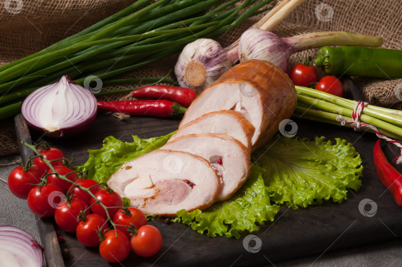 Скачать рулет из варено-копченой курицы, украшенный свежими овощами фотосток Ozero