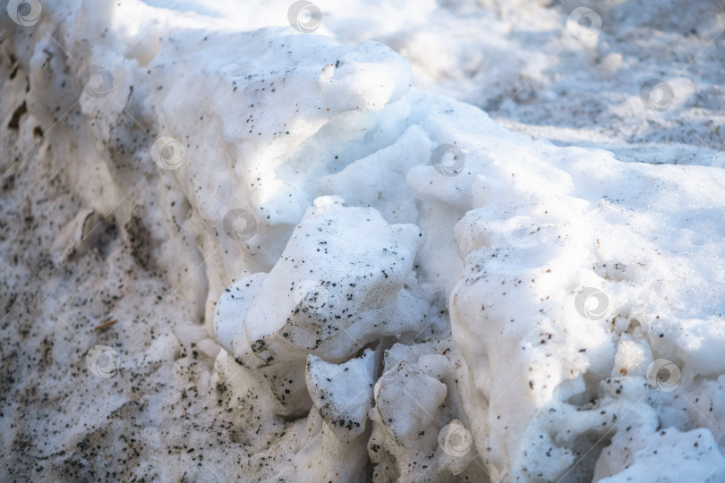 Скачать Грязный тающий снег образует плотную шероховатую текстуру с мелкими частицами грязи и песка, что указывает на приход весны и изменение погодных условий фотосток Ozero