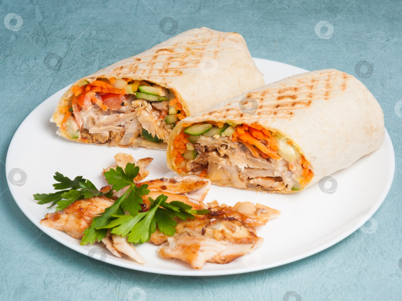 Скачать шаурма с курицей и овощами на синем фоне. Крупный план фотосток Ozero