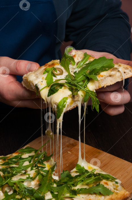 Скачать мужчина берет кусок пиццы. сыр растягивается фотосток Ozero