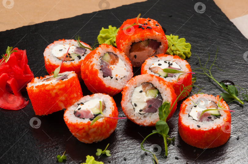 Скачать суши-роллы с лососем, тунцом, огурцом и сливочным сыром в икре тобико фотосток Ozero