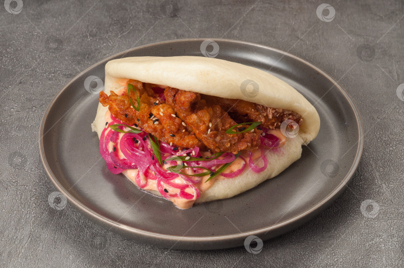Скачать булочка бао с курицей в панировке, маринованным луком и соусом фотосток Ozero