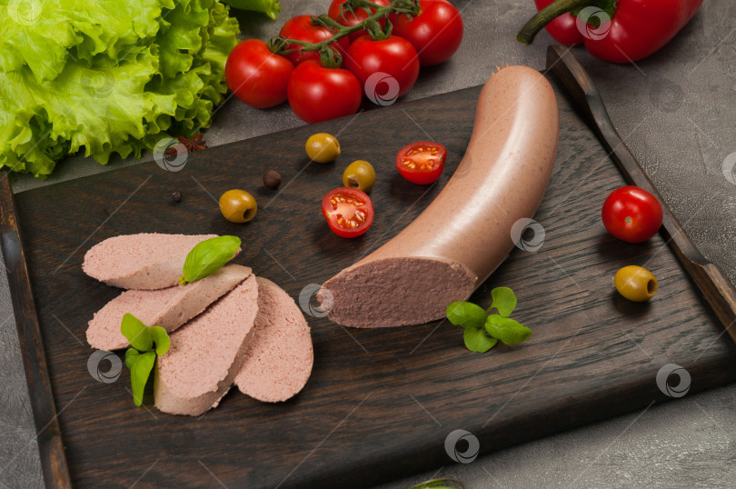 Скачать вареная колбаса из субпродуктов на фоне темного дерева фотосток Ozero