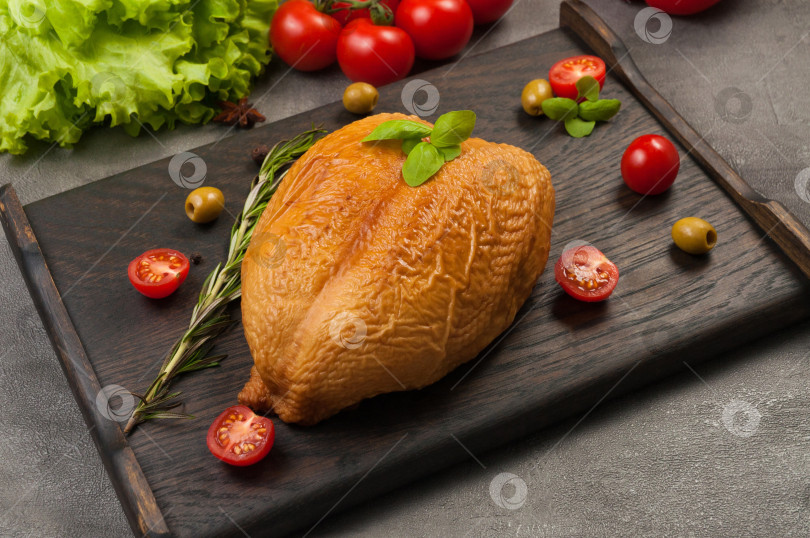 Скачать варено-копченая куриная грудка на темной деревянной доске фотосток Ozero