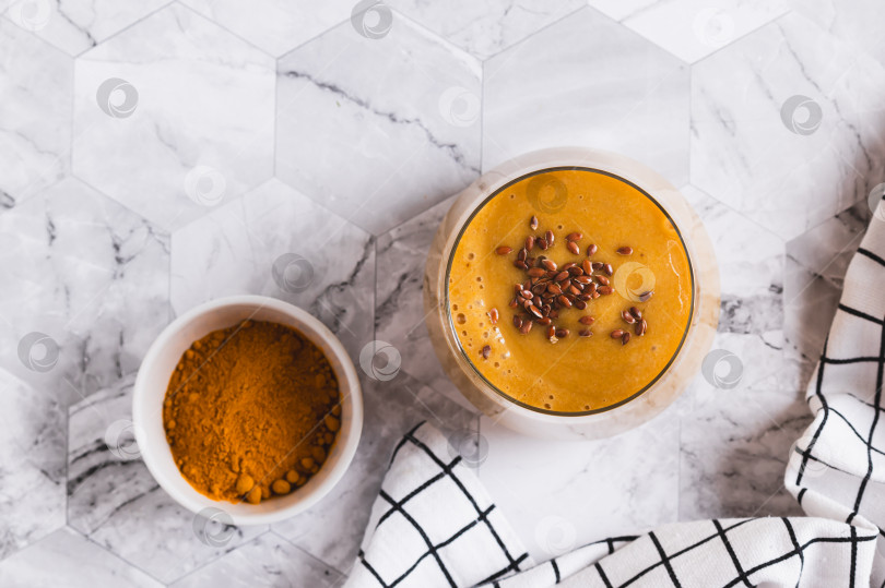 Скачать Смузи из кокосового молока, банана, куркумы и семян льна крупным планом в стеклянной упаковке, вид сверху фотосток Ozero