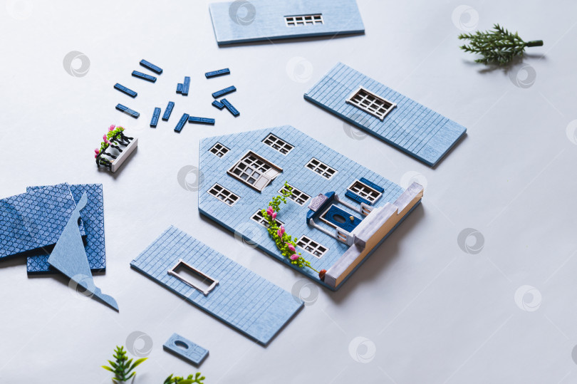 Скачать Детали для сборки миниатюрной модели домика на синем фоне фотосток Ozero