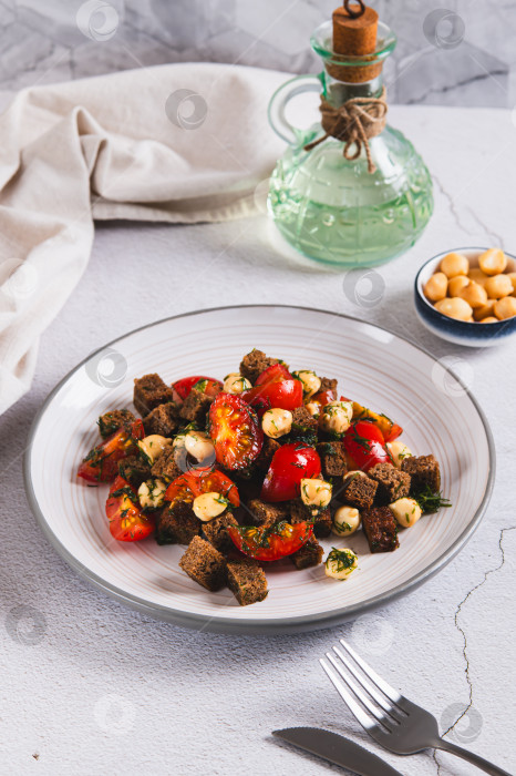 Скачать Смесь из помидоров, сыра и ржаных гренок на тарелке на столе в вертикальном положении фотосток Ozero