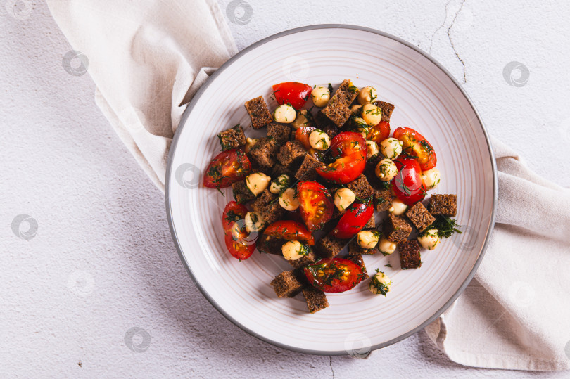 Скачать Салат из ржаного хлеба, помидоров черри и копченого сыра на тарелке, вид сверху фотосток Ozero