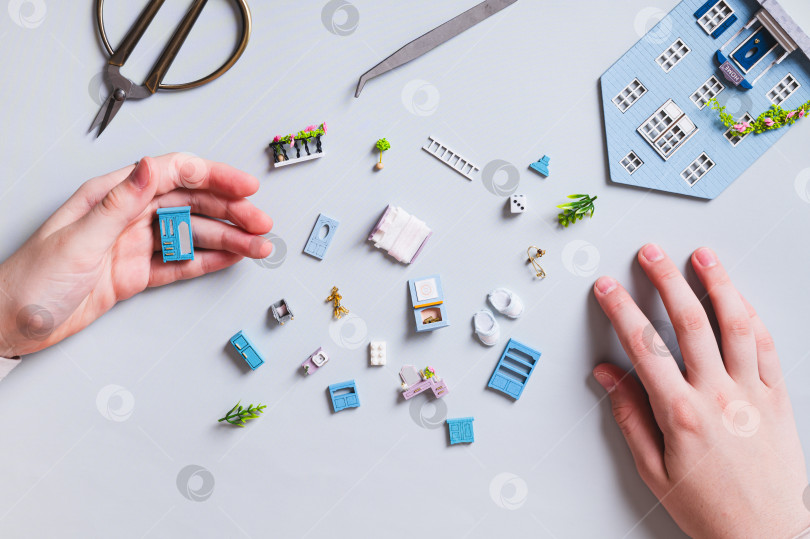 Скачать Миниатюрные детали и мебель для игрушечного домика и детские поделки на голубом фоне, вид сверху фотосток Ozero
