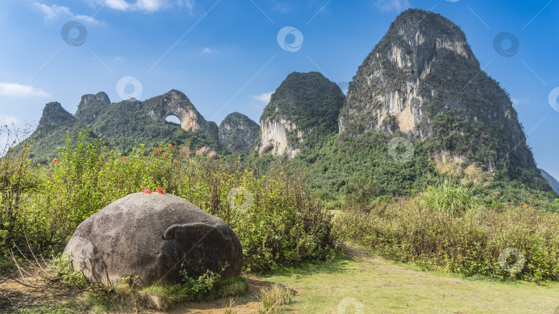 Скачать Живописные карстовые горы, голубое небо. На вершине есть округлое арочное отверстие. фотосток Ozero