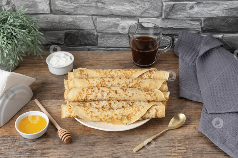 Скачать Стопка блинчиков с медом, йогуртом и кофе на столе на фоне каменной стены фотосток Ozero