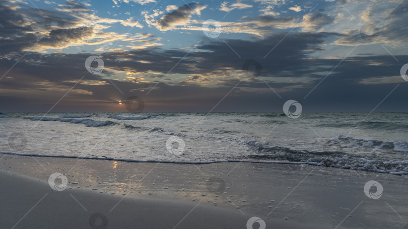 Скачать Закат над океаном. Солнце низко, в темных облаках. фотосток Ozero