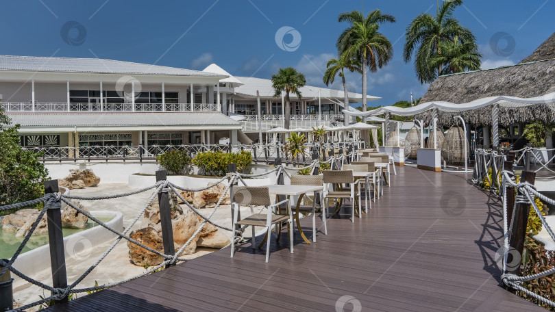 Скачать Столы и стулья расставлены в ряд на променадной террасе. фотосток Ozero